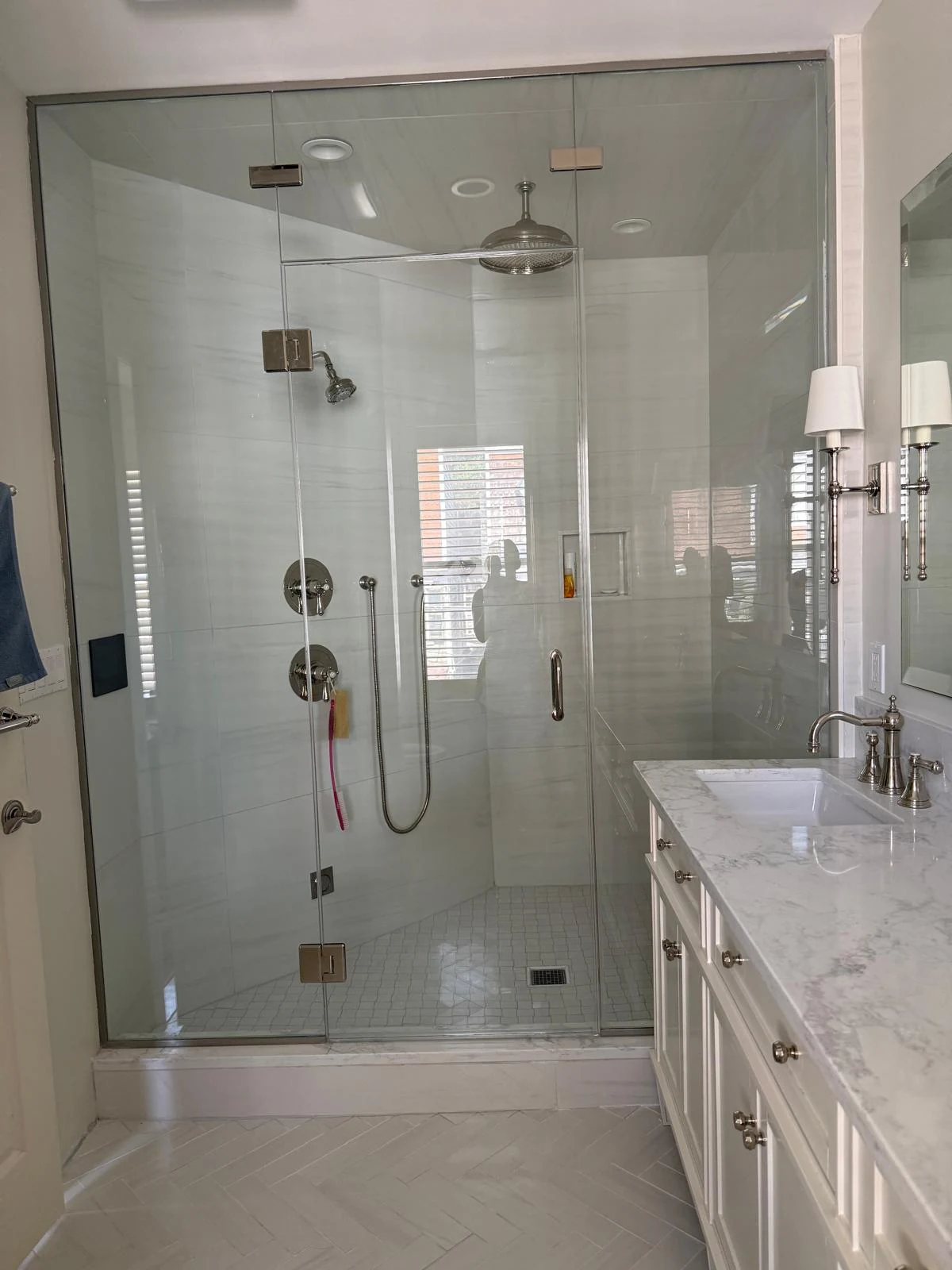 Professionally cleaned glass shower with polished fixtures and tile